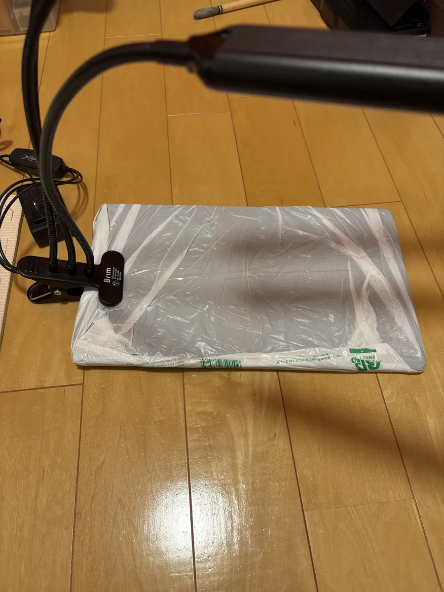 スーパーの袋で包んだ古いまな板にクリップで留めたLEDライト