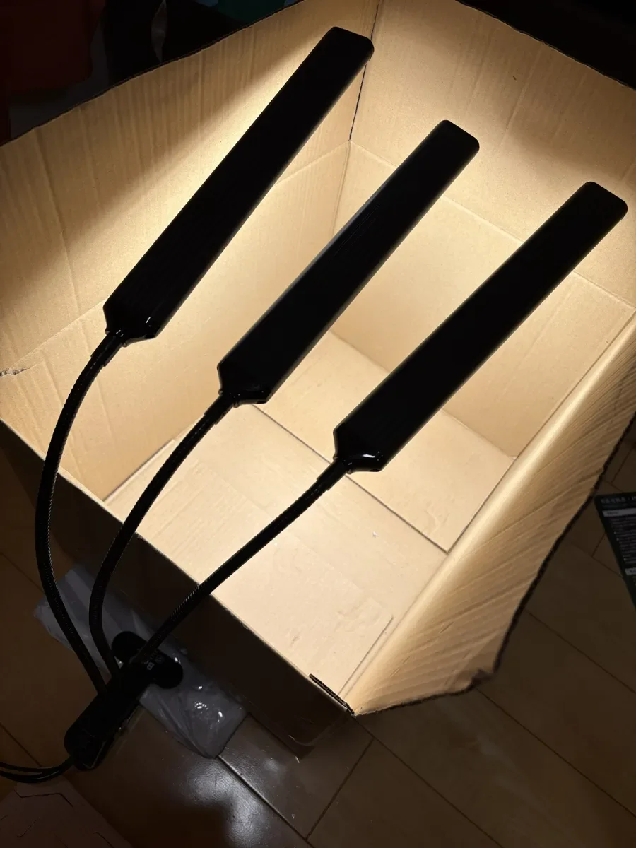 ダンボール箱の中で、LEDライト3本が点灯しているところ